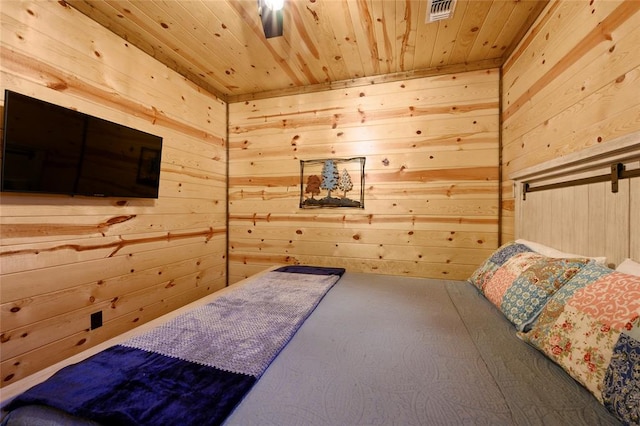 carpeted bedroom with ceiling fan, wooden walls, and wood ceiling