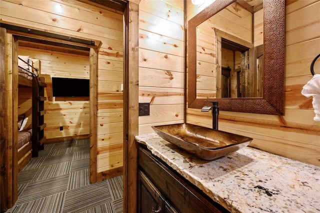 bathroom featuring vanity and wooden walls