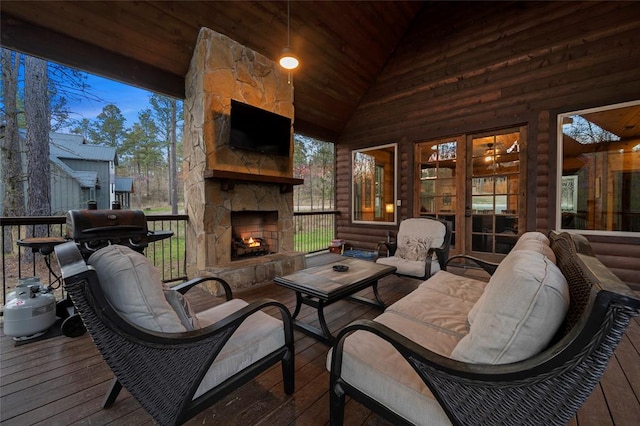 wooden deck with an outdoor living space with a fireplace