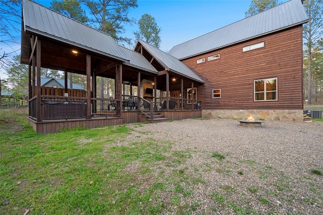 178 Black Jack Trl, Broken Bow, OK 74728 - rear view of property featuring a fire pit, a metal roof, and a porch