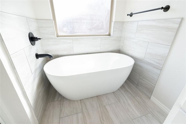 bathroom with tile walls and a washtub