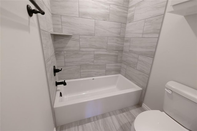 bathroom with toilet and tiled shower / bath combo