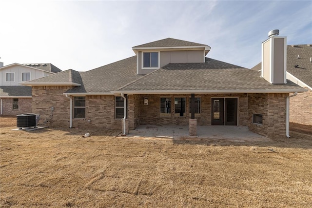 rear view of house with central AC, a patio, and a lawn