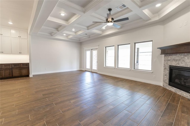 unfurnished living room with coffered ceiling, ceiling fan, a fireplace, and beamed ceiling