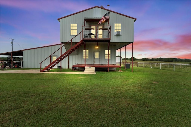 back of property at dusk with stairs, central AC, a lawn, and cooling unit