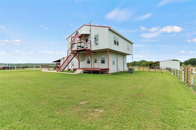 back of property with a rural view, fence, stairway, and central air condition unit