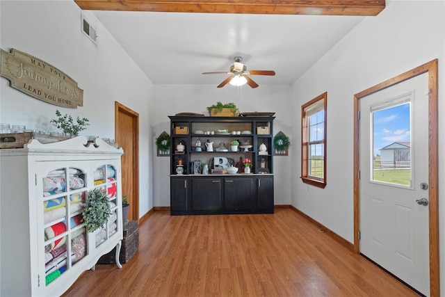 interior space with visible vents, ceiling fan, baseboards, and wood finished floors