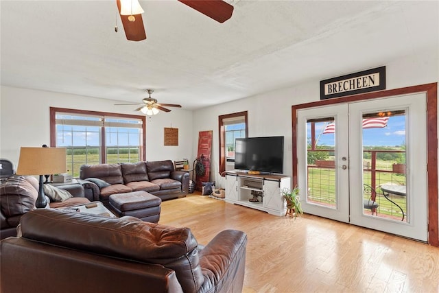 living room featuring light wood-style floors, ceiling fan, and french doors