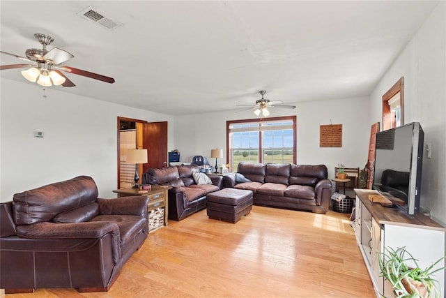 living area featuring ceiling fan, light wood finished floors, and visible vents