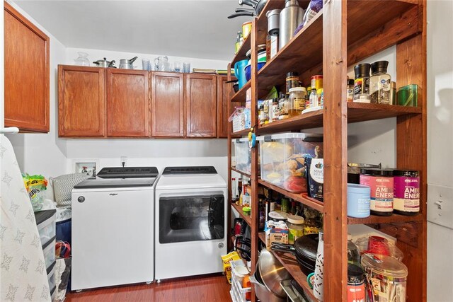 washroom with separate washer and dryer, dark wood-type flooring, and cabinet space