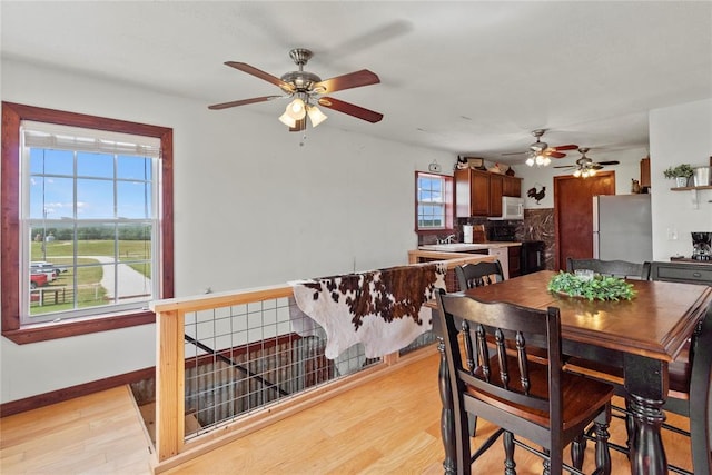 dining room with light wood-style flooring and baseboards