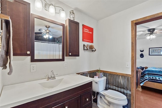 ensuite bathroom featuring vanity, connected bathroom, toilet, and a ceiling fan