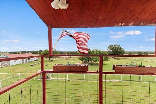 exterior space featuring a rural view, fence, and a lawn