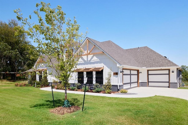 view of front facade with concrete driveway, a shingled roof, an attached garage, and a front yard