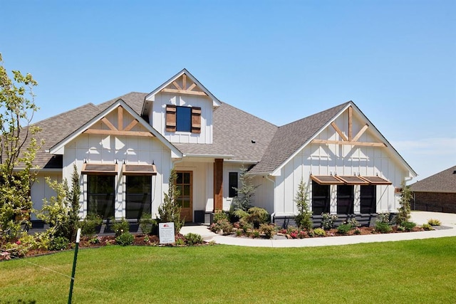 modern inspired farmhouse with a shingled roof and a front yard