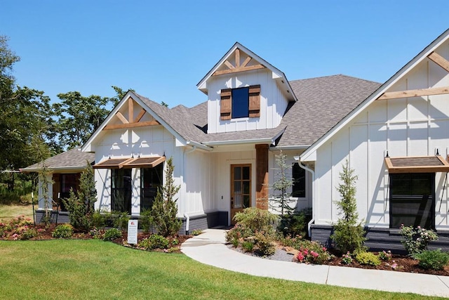 modern farmhouse featuring a shingled roof, board and batten siding, and a front lawn