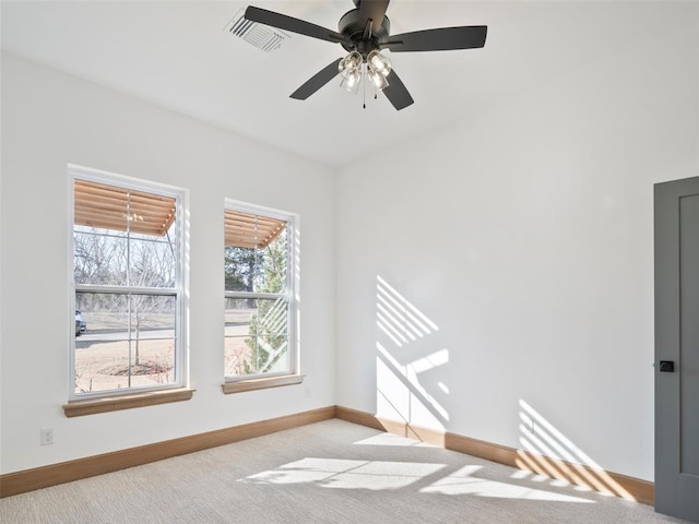 empty room featuring light carpet, ceiling fan, and baseboards