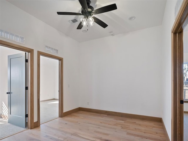 unfurnished room featuring light wood finished floors, baseboards, and visible vents