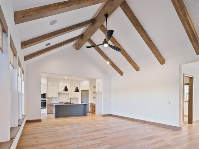 unfurnished living room with high vaulted ceiling, visible vents, light wood-style floors, and beamed ceiling