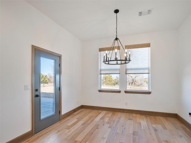unfurnished dining area with light wood-style floors, visible vents, plenty of natural light, and baseboards