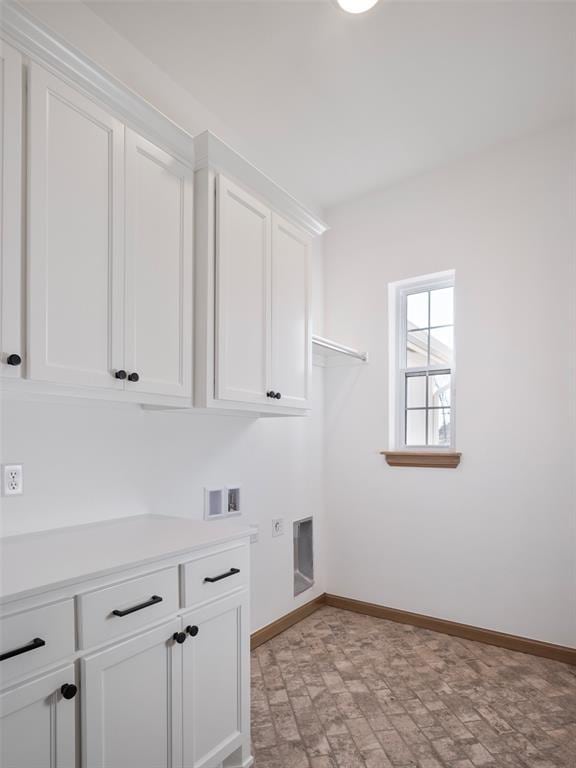 laundry area featuring washer hookup, cabinet space, electric dryer hookup, and baseboards