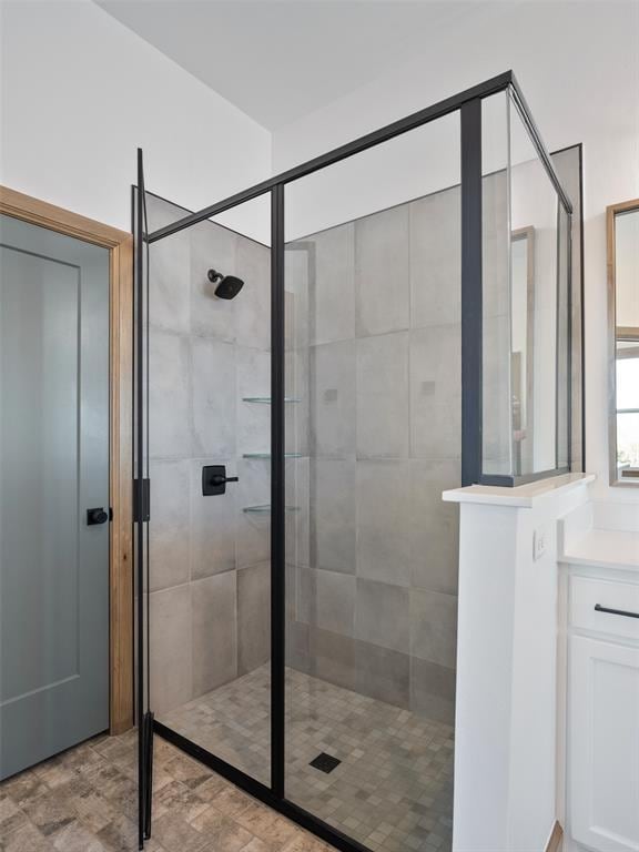 full bath with a tile shower and vanity