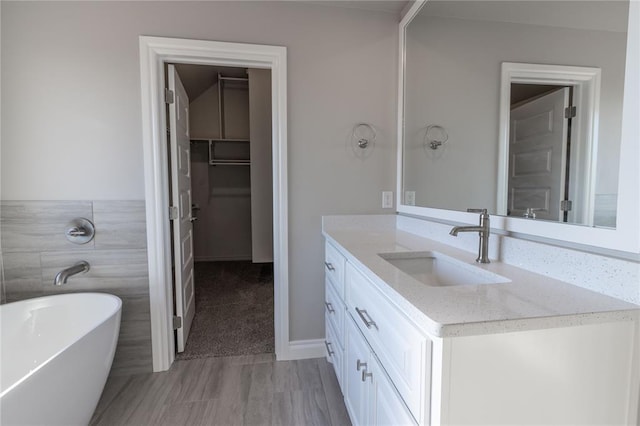 bathroom featuring a washtub, wood-type flooring, and vanity