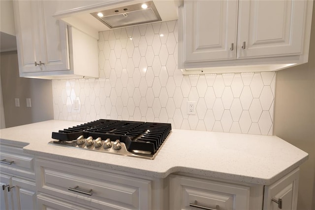 kitchen with white cabinets, exhaust hood, stainless steel gas cooktop, and tasteful backsplash