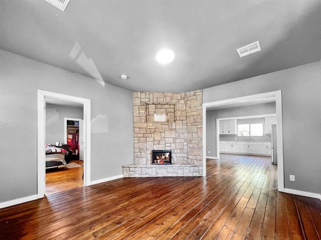 unfurnished living room featuring a fireplace and wood-type flooring