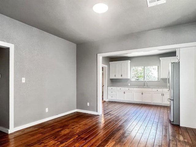 kitchen featuring white cabinets, stainless steel fridge, sink, and dark wood-type flooring