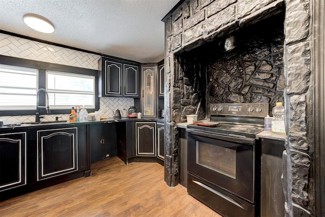 667 County Road 1410th Rd, Ninnekah, OK 73067 - kitchen featuring black / electric stove, a sink, a textured ceiling, backsplash, and light wood-style floors