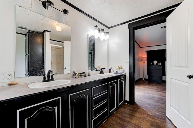 667 County Road 1410th Rd, Ninnekah, OK 73067 - full bath featuring a textured ceiling, wood finished floors, double vanity, and crown molding