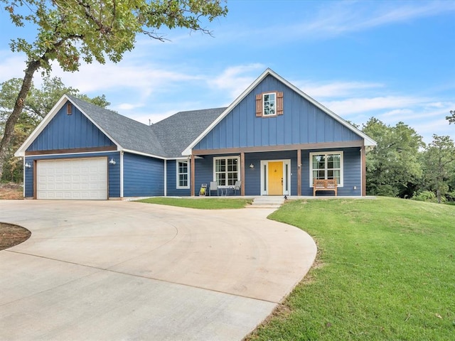 view of front of property with a garage, covered porch, and a front yard