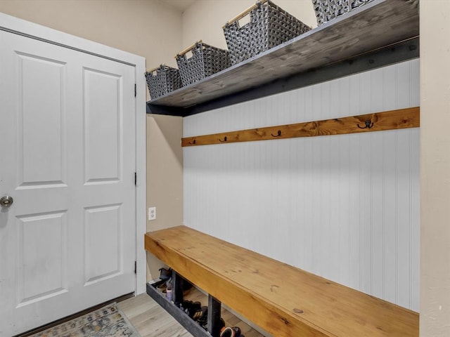 mudroom featuring light hardwood / wood-style flooring and wooden walls