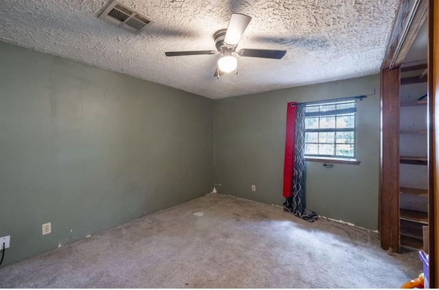 carpeted empty room featuring a textured ceiling and ceiling fan