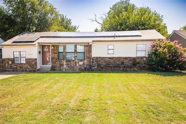 view of front of home featuring solar panels and a front lawn