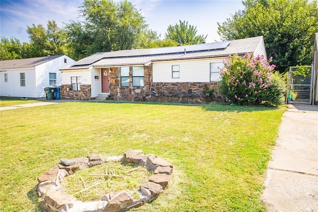 view of front of property with solar panels and a front yard