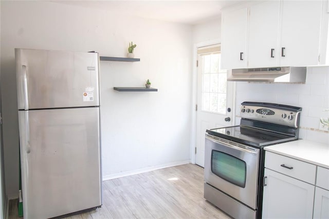 kitchen featuring white cabinets, light wood-type flooring, stainless steel appliances, and extractor fan