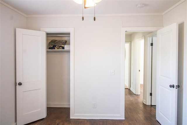 unfurnished bedroom with dark hardwood / wood-style floors, ornamental molding, and a closet