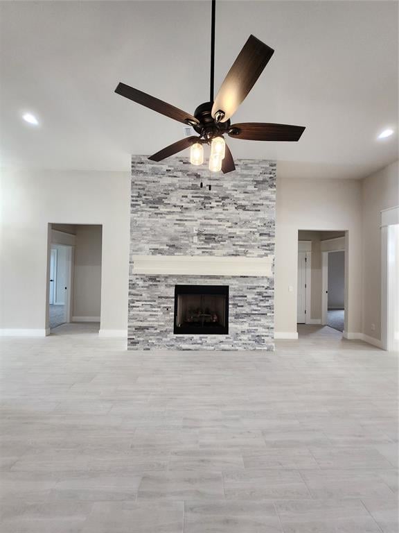 unfurnished living room with ceiling fan and a fireplace