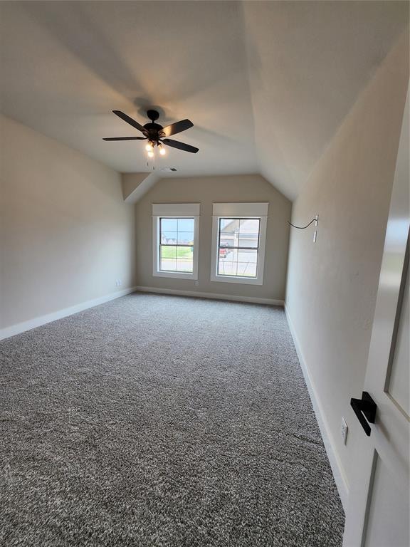 carpeted empty room with ceiling fan and lofted ceiling