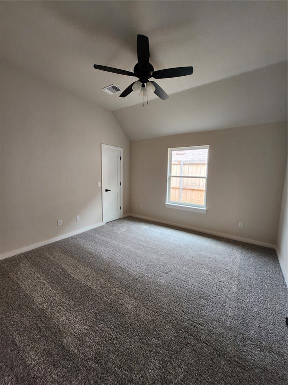 9320 SW 34th St, Oklahoma City, OK 73179 - spare room featuring lofted ceiling, carpet flooring, baseboards, and a ceiling fan
