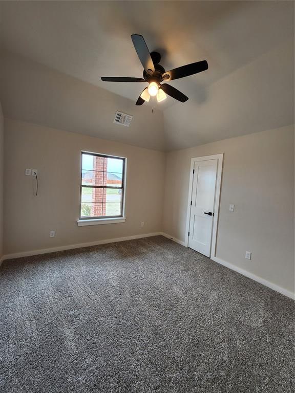 carpeted empty room with ceiling fan and lofted ceiling