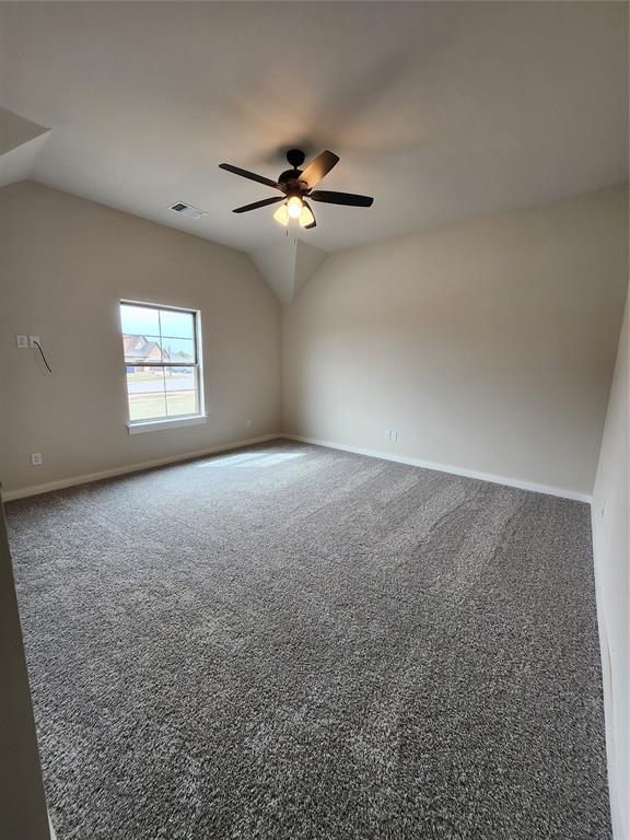 9320 SW 34th St, Oklahoma City, OK 73179 - carpeted empty room with lofted ceiling, baseboards, and a ceiling fan