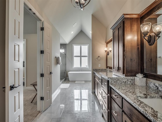 bathroom featuring lofted ceiling, vanity, and a bathtub