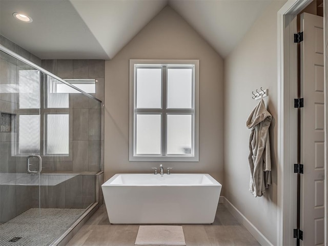 bathroom featuring plenty of natural light, lofted ceiling, and separate shower and tub