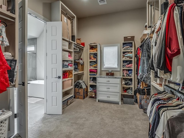 walk in closet featuring light carpet