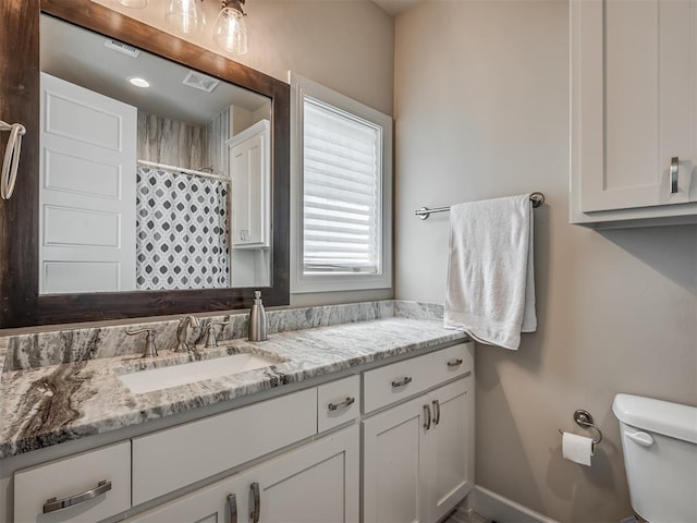 bathroom featuring vanity, toilet, and a shower with shower curtain