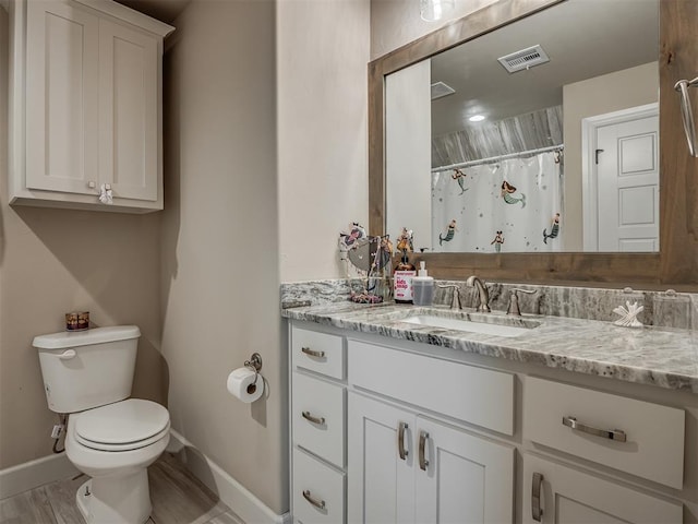 bathroom featuring hardwood / wood-style flooring, vanity, curtained shower, and toilet