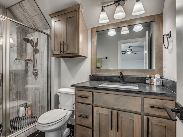 bathroom featuring vanity, ceiling fan, a shower with door, and toilet